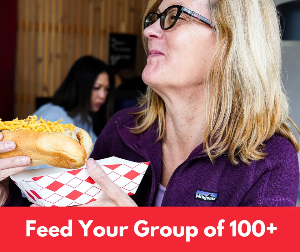 a woman enjoys a bite of her hot dog