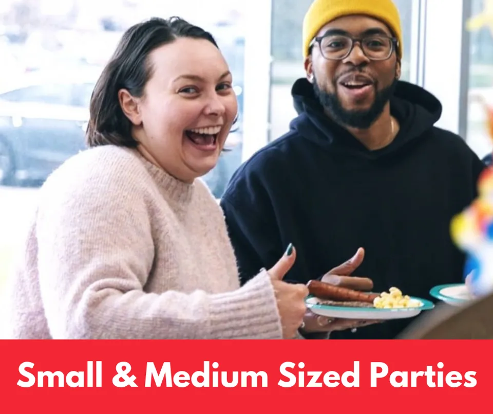 Two people smile eating Steve's Hot Dogs catering. The photo says "Small and Medium Sized Parties" over top