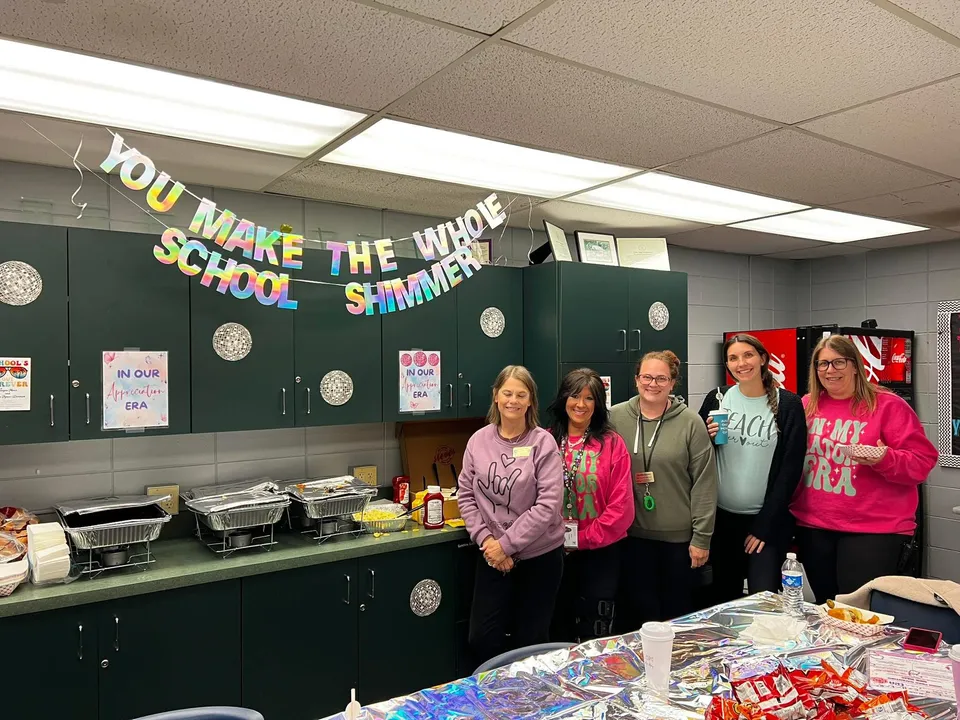 A group of teachers stand in front of their buffet catered by Steve's Hot Dogs St Louis